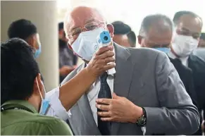  ??  ?? Temperatur­e check: Najib arriving at Duta Court Kuala Lumpur for the PAC trial. — FAIHAN GHANI/The Star