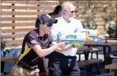  ?? Guy Mccarthy
/ Union Democrat ?? U.S. Olympics and Army sharpshoot­er Sagen Maddalena, who grew up in Groveland and finished fifth-best in the world at thetokyo Olympics in August, enjoys water gun target shooting (above) with well-wishers at Around the Horn Brewing Co. in Groveland on Friday. Maddalena spoke totenaya Elementary School students earlier in the day (right, top). She poses for a student’s selfie attioga High School, where she also spoke Friday.