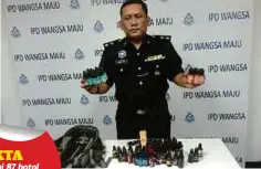  ??  ?? MOHAMAD Roy menunjukka­n 87 botol perisa vape yang ditemui dalam beg di PPR Ayer Panas, Setapak.