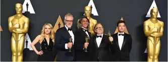  ??  ?? Christophe­r Nelson, second from left, Giorgio Giorgio, center, and Alessandro Bertolazzi, second from right, winners of the award for best makeup and hairstylin­g for "Suicide Squad" pose in the press room with Kate McKinnon, left, and Jason Bateman,...