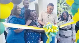  ?? ?? Prime Minister Andrew Holness (second right) takes part in the ribbon cutting for the handover of a house to Gillian Coleman (right) in St Catherine on Wednesday.