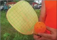 ??  ?? When a polymer ball and wooden racket collide, a sweet sound is made during a game of pickleball.