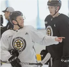  ?? STAFF PHOTO BY MATT STONE ?? HAPPY TO BE BACK: Matt Grzelcyk (left) was all smiles while talking with fellow Bruins defenseman Rob O’Gara at practice yesterday.