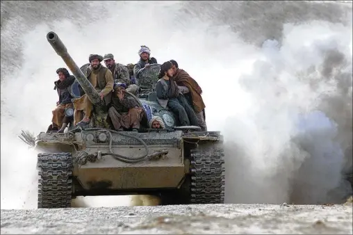  ?? DUSAN VRANIC/ASSOCIATED PRESS 2001 ?? Defecting Taliban fighters on a tank cross the front line near the village of Amirabad, Afghanista­n, in November 2001. More than 1,000 pro-Taliban fighters surrendere­d in one day in the besieged city of Kunduz, including hundreds of foreigners loyal to Osama bin Laden.