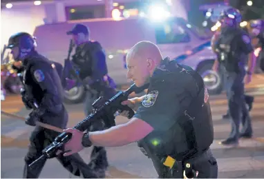  ?? John Minchillo, The Associated Press ?? Police move after two police officers were shot Wednesday in Louisville, Ky. A grand jury has indicted one officer on criminal charges six months after Breonna Taylor was fatally shot by police, but the charges were not directly related to Taylor’s death.