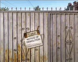  ?? RUIZ ?? and her husband live on South Figueroa Street behind a gate with a demolition sign. They currently pay $1,560 a month for a two-bedroom unit.