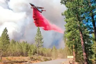  ?? BOOTLEG FIRE INCIDENT COMMAND VIA AP ?? A tanker drops fire retardant over the Mitchell Monument area at the Bootleg Fire in southern Oregon on Saturday. The 606-square-mile fire is burning 300 miles southeast of Portland in and around the Fremont-Winema National Forest.