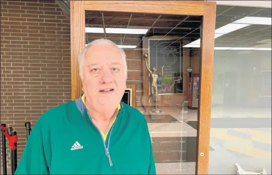  ?? MIKE HUTTON/POST-TRIBUNE ?? Bob Punter stands in front of the trophy case that holds the 1994 state basketball runner-up trophy on Thursday. His Vikings lost 93-88 in overtime to South Bend Clay in the state final.