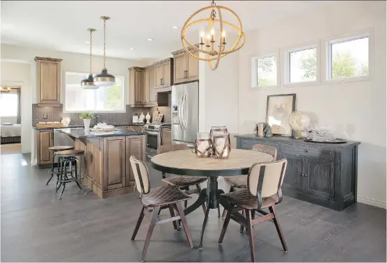  ?? PHOTOS: HOPEWELL RESIDENTIA­L ?? An eye-catching L-shaped kitchen offers plenty of walking-around room and wraps along two sides of an island and extended eating bar with stools to seat two. An open-concept design connects the kitchen to a dining area