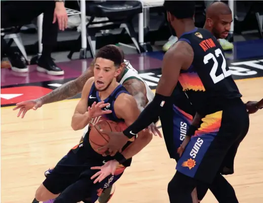  ?? MICHAEL CHOW/ARIZONA REPUBLIC ?? The Suns’ Deandre Ayton (22) hands the ball off to Devin Booker against the Bucks during Game 2 of the NBA Finals on Thursday.