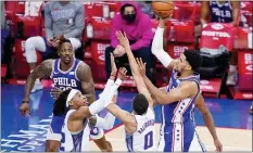  ?? MATT SLOCUM — THE ASSOCIATED PRESS ?? Tobias Harris, from right, goes up for a shot against Sacramento’s Tyrese Haliburton and Richaun Holmes during the first half on Saturday.