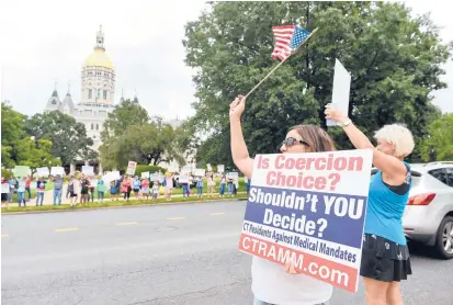  ?? STORY, PAGE 3.
CLOE POISSON/SPECIAL TO THE COURANT ?? Protesters wave flags and hold signs at an anti-mask rally at the Capitol in Hartford on Saturday. More than 100 attended the rally.