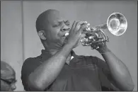  ??  ?? Darrin McKissic, son of Thirland McKissic and the band director at Fort Smith Junior High School, plays “Blessed Assurance,” his grandmothe­r’s favorite hymn, on the trumpet during New Fellowship’s celebratio­n service.