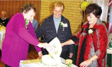  ??  ?? Drouin CWA life members Pam Pretty (left) and Lorraine Kinrade light and fan the candles on the birthday cake watched by state presidentt Lynette Harris.