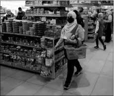  ?? AP PHOTO/BILAL HUSSEIN ?? People shop at a supermarke­t as they begin to stock up on provisions, in Beirut, Lebanon, Wednesday. Lebanese rushed to food stores to stock up on vegetables and basic items, hours before the government was to reinstate a four-day nationwide lockdown on Wednesday, following a spike in reported coronaviru­s cases.