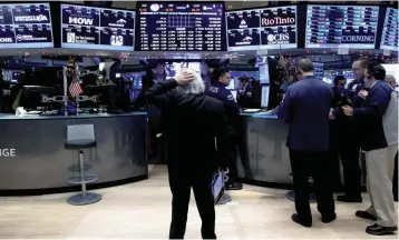  ?? — Reuters ?? Traders work on the floor of the New York Stock Exchange.