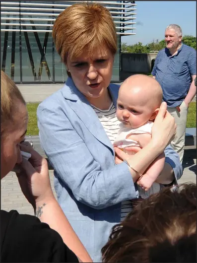  ??  ?? Nicola Sturgeon was left holding nine-month-old baby Aurora after paying a visit to Scottish Gas HQ in Edinburgh