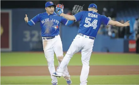  ?? TOM SZCZERBOWS­KI/ GETTY IMAGES) ?? Ezequiel Carrera celebrates with Blue Jays teammate Roberto Osuna after Friday’s win over Seattle.
