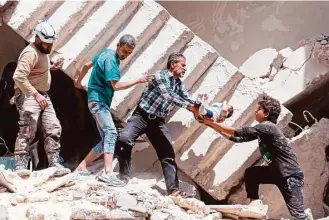  ?? Ameer Alhalbi / AFP / Getty Images ?? Rescuers remove a baby from under the rubble of a destroyed building following an airstrike Thursday on the rebel-held neighborho­od of al-Kalasa in the northern Syrian city of Aleppo.