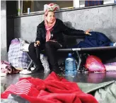  ?? AFP ?? A migrant woman takes shelter from the rain at the entrance of Sarajevo’s railway station in June, 2018.