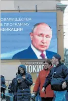  ?? ?? Moscú. Ciudadanos pasan frente a un cartel de Vladímir Putin.