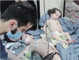  ?? SYRIAN CIVIL DEFENCE WHITE HELMETS PHOTOS THE ASSOCIATED PRESS ?? This image made from video released by the Syrian Civil Defence White Helmets shows medical workers treating toddlers following an alleged poison gas attack in the opposition-held town of Douma, in eastern Ghouta, near Damascus.