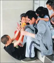  ?? BAI QINGXIA / FOR CHINA DAILY ?? Guo Xiaoping, the head of Linfen Red Ribbon School in Shanxi province, plays with his students.