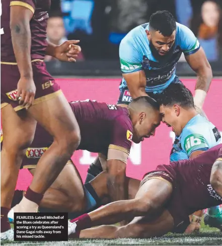  ??  ?? FEARLESS: Latrell Mitchell of the Blues celebrates after scoring a try as Queensland’s Dane Gagai rolls away from his missed tackle.