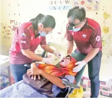  ??  ?? PEGAWAI Perubatan Pergigian Pitas, Dr Phang Khyun Lee (kiri) sedang mengadakan rawatan pergigian kepada salah seorang pesakit.