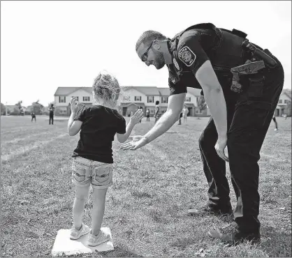  ?? [KYLE ROBERTSON/DISPATCH] ?? Carlee Gaul, 3, gets a high-five from Obetz Police Officer Michael Fout at first base during the kickball game Monday at Douglas Community Center.