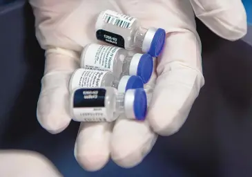  ?? EDDIE MOORE/JOURNAL ?? Vials containing the Pfizer COVID-19 vaccine. Given the small risk of severe allergic reaction and its treatable nature, the risk of catching the coronaviru­s and becoming severely ill or dying far outweighs that of a potential allergic reaction, Centers for Disease Control and Prevention officials said.