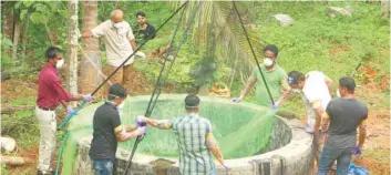  ?? — AFP ?? Animal husbandry department and forest officials inspect a well to catch bats at Changaroth in Kozhikode on Monday.