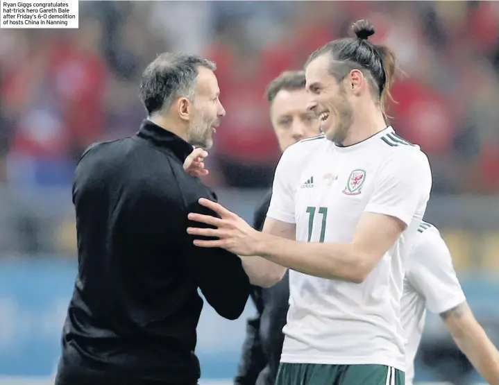  ??  ?? Ryan Giggs congratula­tes hat-trick hero Gareth Bale after Friday’s 6-0 demolition of hosts China in Nanning