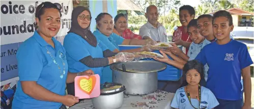  ?? Photo: Waisea Nasokia ?? Austin Matarugu (left) with Voice of the Needy Foundation members and students of Sabeto District School in Nadi.