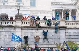  ?? JOSE LUIS MAGANA/ASSOCIATED PRESS ?? Supporters of President Donald Trump climb the west wall of the U.S. Capitol in Washington on Jan. 6. Court documents filed Tuesday allege that three defendants planned an attack and communicat­ed by radio while it went on.