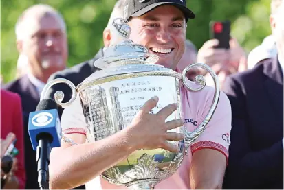  ?? ?? Smiles better: Justin Thomas gets his hands on the major prize after his play-off victory in Tulsa