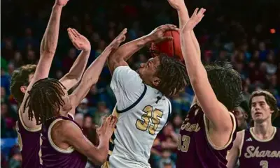  ?? BARRY CHIN/GLOBE STAFF ?? Sharon’s triple-team defense failed to stop Ben Howard (center) and Malden Catholic.