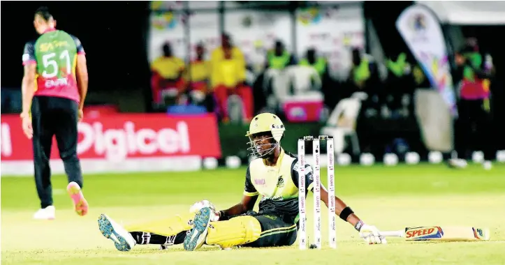  ??  ?? Shamar Springer from the Jamaica Tallawahs was left flat on the ground after a wild swing and miss off the bowling of Rayad Emrit in a Caribbean Premier League at Sabina Park yesterday.