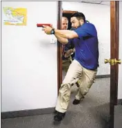 ??  ?? NICK GUADARAMA demonstrat­es how to enter a room with active gunfire during the training class.