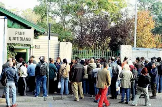  ??  ?? Pasti gratuiti La fila di persone che attendono la distribuzi­one di cibo in viale Toscana