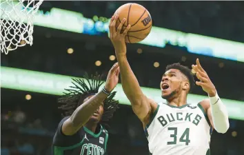  ?? ADAM GLANZMAN/GETTY ?? Giannis Antetokoun­mpo of the Milwaukee Bucks drives to the basket past Robert Williams III of the Boston Celtics during Game 1 of the Eastern Conference Semifinals on Sunday.