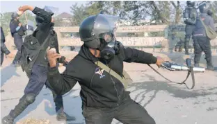  ?? — AFP ?? A Pakistani riot policeman throws a rock towards protesters in Islamabad on Saturday.
