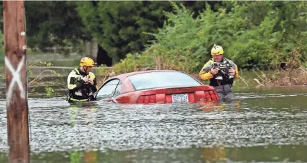  ??  ?? Members of a rescue team check a submerged vehicle in New Bern, N.C., on Saturday.