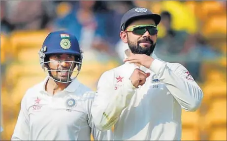  ?? PTI PHOTO ?? India captain Virat Kohli asks for a review as wicketkeep­er Wriddhiman Saha looks on during the second day of the second Test in Bangalore on Sunday.