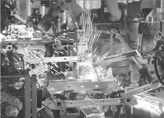  ?? GETTY IMAGES FILES ?? Robots weld elements to a car’s chassis on the assembly line at an auto factory in France. Repetitive tasks in manufactur­ing plants are being taken over by machines.