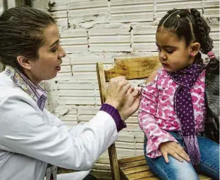  ?? Jardiel Carvalho/folhapress ?? A pequena Rihanna Caetano Ribeiro observa agente de saúde lhe aplicar vacina na manhã de ontem, no posto de saúde Dona Mariquinha Sciáscia, no Tremembé