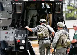  ?? JOSHUA BOUCHER / (PANAMA CITY) NEWS HERALD ?? Bay County sheriff’s deputies enter an armored vehicle Tuesday in Panama City in response to a shooter later found dead.