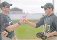  ??  ?? Head coach Mark Quinn, left, welcomes Montague’s Nolan Hicken back to the dugout after the third baseman caught a line drive and threw to first for the double play Wednesday at the Canada Games. Hicken has a .555 (5-for-9) batting average.