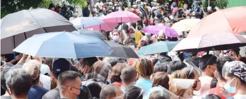  ?? PHOTOGRAPH BY JOEY SANCHEZ MENDOZA FOR THE DAILY TRIBUNE ?? RESIDENTS crowd the entrance to the Ospital ng Maynila to get their first dose of the AstraZenec­a vaccine Monday, part of the City of Manila’s Covid-19 vax rollout.