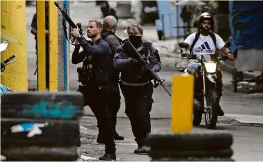  ?? Fabiano Rocha - 6.mai.21/Agência O Globo ?? Policiais armados participam de operação no Jacarezinh­o, no Rio, na semana passada